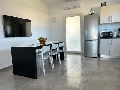 a kitchen with a table with chairs and a refrigerator at Mira Sea View Residence in Chania Town