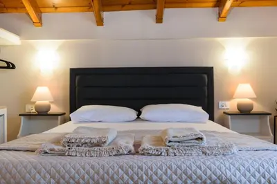 a bedroom with a bed with two pillows and two lamps at Marianthi's Maisonette in Chania Town