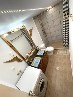 a bathroom with a sink and a toilet with a mirror at Village Villa Mimis Drapanias in Drapaniás