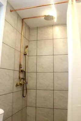 a shower in a bathroom with a shower curtain at Village Villa Mimis Drapanias in Drapaniás