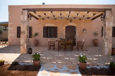 an outdoor patio with a table and chairs at Iliopetra Villa in Beritianá