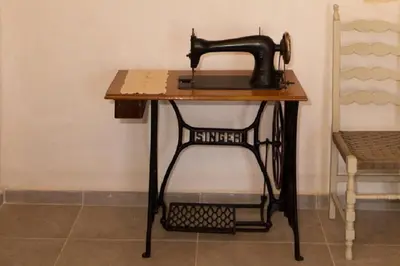 a sewing machine sitting on a table next to a chair at Iliopetra Villa in Beritianá