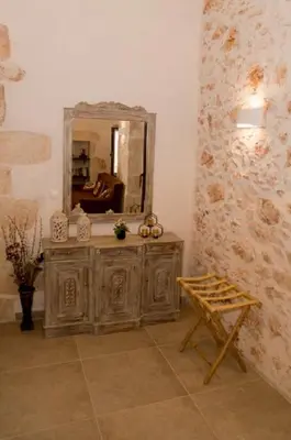 a bathroom with a vanity with a mirror and a chair at Iliopetra Villa in Beritianá