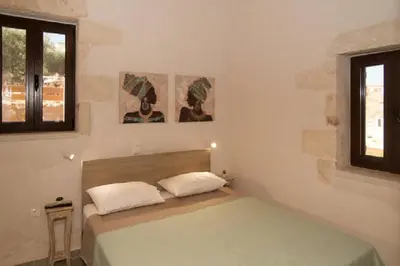 a bedroom with a bed and two pictures on the wall at Iliopetra Villa in Beritianá