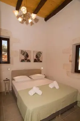 a bedroom with a bed with two towels on it at Iliopetra Villa in Beritianá