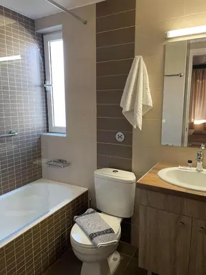a bathroom with a toilet and a tub and a sink at Theos Holidays Apartments in Kato Daratso