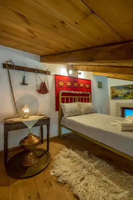 a bedroom with a bed and a table and a rug at Traditional Cretan Villa George - Private Pool in Kambánion