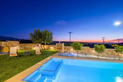 a villa with a swimming pool at night at Traditional Cretan Villa George - Private Pool in Kambánion