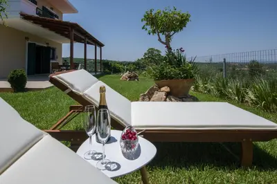 a table with glasses and a bottle of wine at Hilltop Villa Kontomari in Kondomari