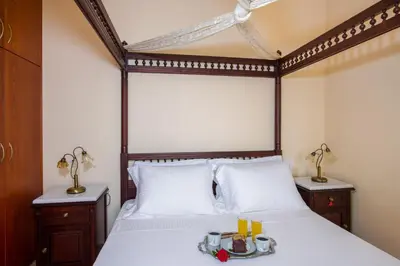 a bedroom with a bed with a wooden head board at Hilltop Villa Kontomari in Kondomari