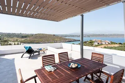 a patio with a wooden table and chairs at Villa Kiara 2 in Tersanas