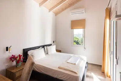 a white bedroom with a bed and a window at Villa Kiara 2 in Tersanas