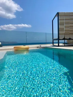 a swimming pool with a chair and some water at Luxury Villa Dioskouroi Heated eco pool & jacuzzi in Kalyves