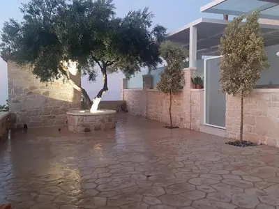 a courtyard with a tree and a fountain at Luxury Villa Dioskouroi Heated eco pool & jacuzzi in Kalyves
