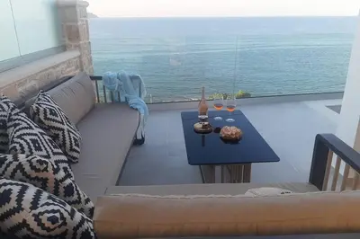 a couch and a table with a view of the ocean at Luxury Villa Dioskouroi Heated eco pool & jacuzzi in Kalyves