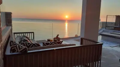 a living room with a view of the ocean at sunset at Luxury Villa Dioskouroi Heated eco pool & jacuzzi in Kalyves