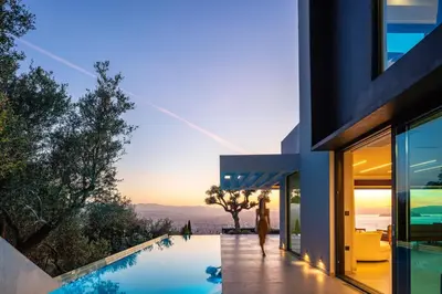 a house with a swimming pool next to a building at Cavo Dago in Chania Town
