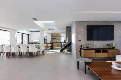 a dining room with a table and a flat screen tv at Cavo Dago in Chania Town
