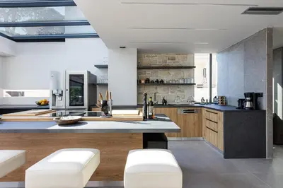 a kitchen with a large island with white stools at Cavo Dago in Chania Town