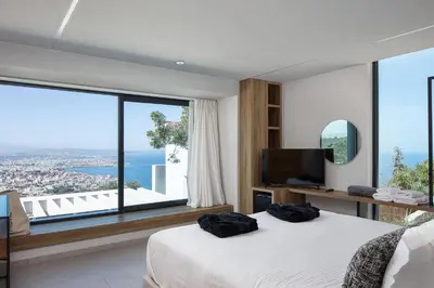 a bedroom with a bed and a large window at Cavo Dago in Chania Town