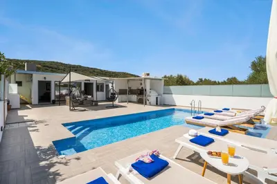a villa with a swimming pool and lounge chairs at Villa Alitocatos in Drapaniás