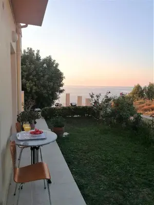 a table and chairs on a patio with a view of the ocean at Emerald Apartment 2 Halepa in Chania Town