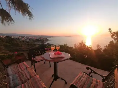 a table with two glasses of wine with a view of the ocean at Emerald Apartment 2 Halepa in Chania Town