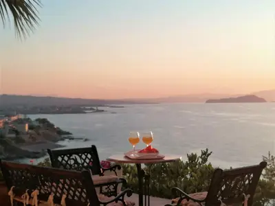 two glasses of wine sitting on a table overlooking the ocean at Emerald Apartment 2 Halepa in Chania Town