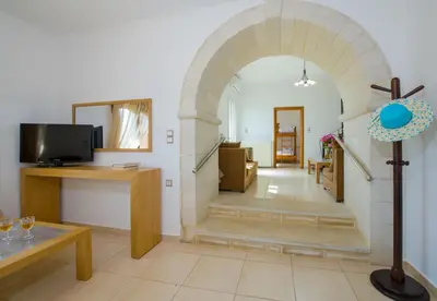 a living room with an archway with a tv at Lilium Stone Villa in Varípetron