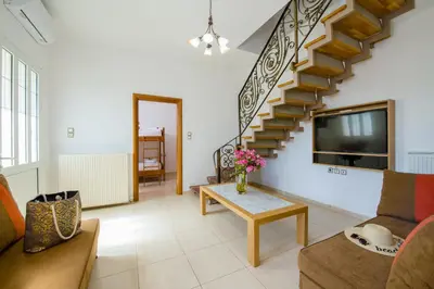 a living room with a couch and a table at Lilium Stone Villa in Varípetron