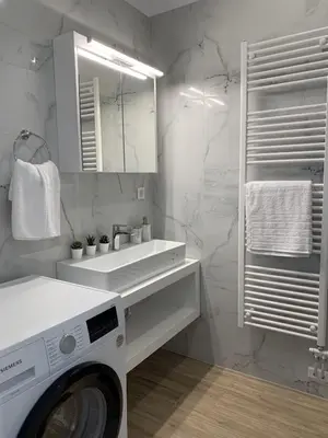 a white bathroom with a washing machine and a sink at Leonidas House in Chania Town