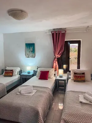 a room with three beds and a window at Platanos Stone House I With Shared Pool in Kalyves