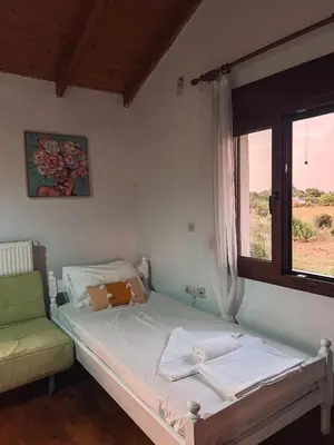 a small bedroom with a bed and a window at Platanos Stone House I With Shared Pool in Kalyves