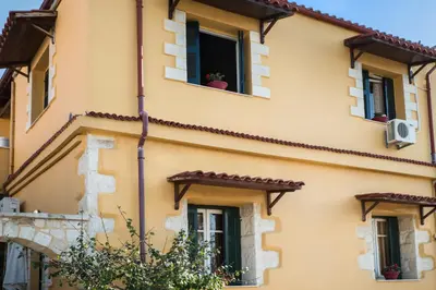 a yellow building with windows and a plant in the window at Dominic Chania 2 Room Apartment in Chania Town