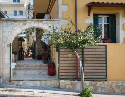 a tree in front of a building with an arch at Dominic Chania 2 Room Apartment in Chania Town