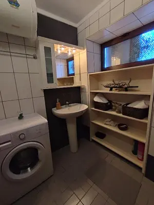 a bathroom with a washing machine and a sink at Grandma Agatha & Virginia's stonehouse in Kefálion