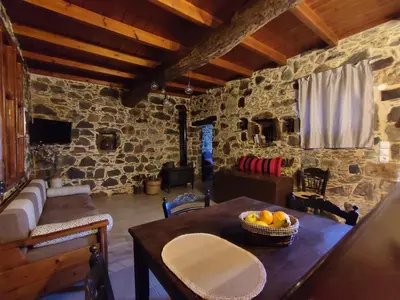 a room with a table with a bowl of fruit on it at Grandma Agatha & Virginia's stonehouse in Kefálion