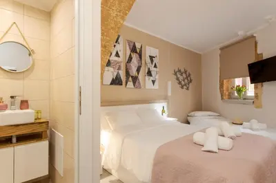 a bedroom with two white beds and a sink at Mitos Cozy Rooms in Chania Town