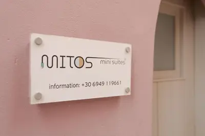 a sign on the side of a pink wall at Mitos Cozy Rooms in Chania Town