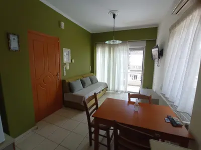 a living room with green walls and a table and a couch at Tasos Seagull apartments in Chania Town