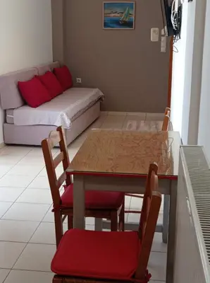 a room with a table and chairs and a couch at Tasos Seagull apartments in Chania Town