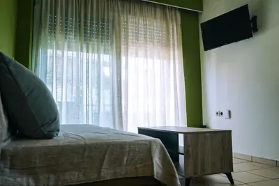 a bedroom with a bed and a window with a table at Tasos Seagull apartments in Chania Town