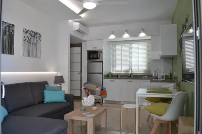 a living room with a couch and a kitchen at Filia Luxury Apartment in Chania Town