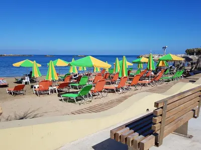 a bunch of chairs and umbrellas on a beach at Filia Luxury Apartment in Chania Town