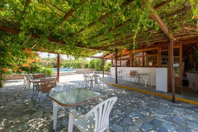 a patio with tables and chairs under a pergola at Ohana in Kamisianá