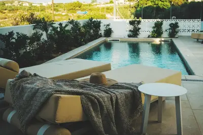 a swimming pool with a table and a blanket next to it at Lux sea view villa by Chania LIving Stories in Chania Town
