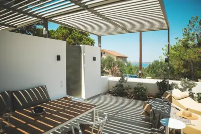 a patio with a table and chairs and a view of the ocean at Lux sea view villa by Chania LIving Stories in Chania Town