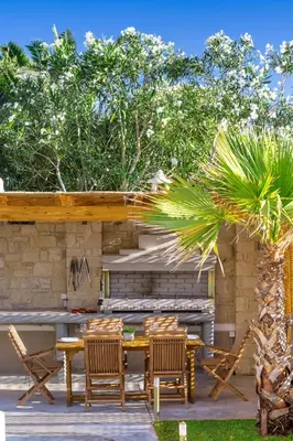 a patio with a table and chairs and a fireplace at Villa Persephone in Tavronitis