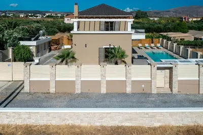 a house with a fence and a swimming pool at Villa Persephone in Tavronitis