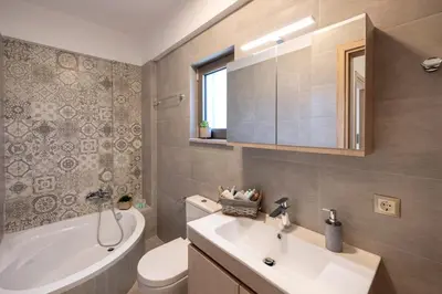 a bathroom with a sink and a toilet and a tub at Villa Persephone in Tavronitis
